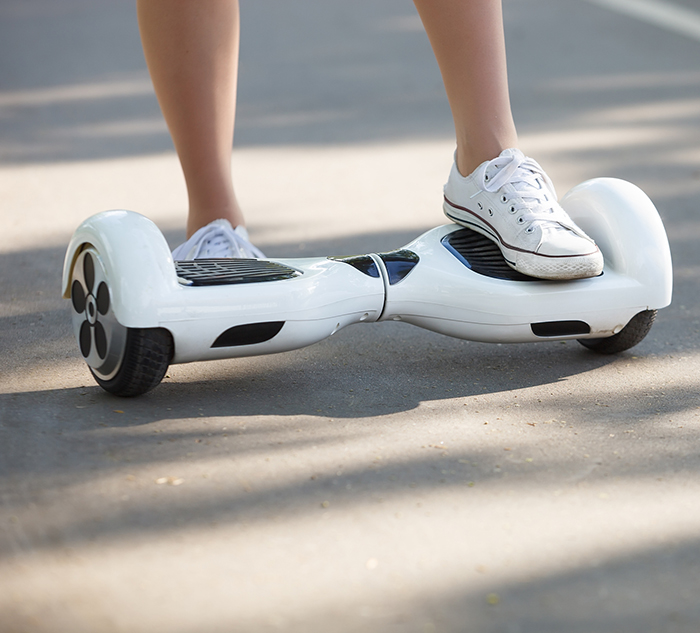 Feet of girl riding electric mini hoverboard scooter