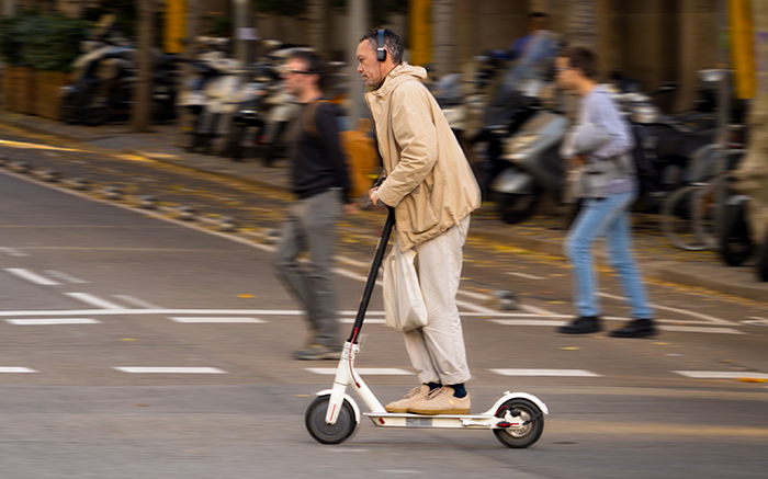 A person on electric scooter in a street of Barcelona.